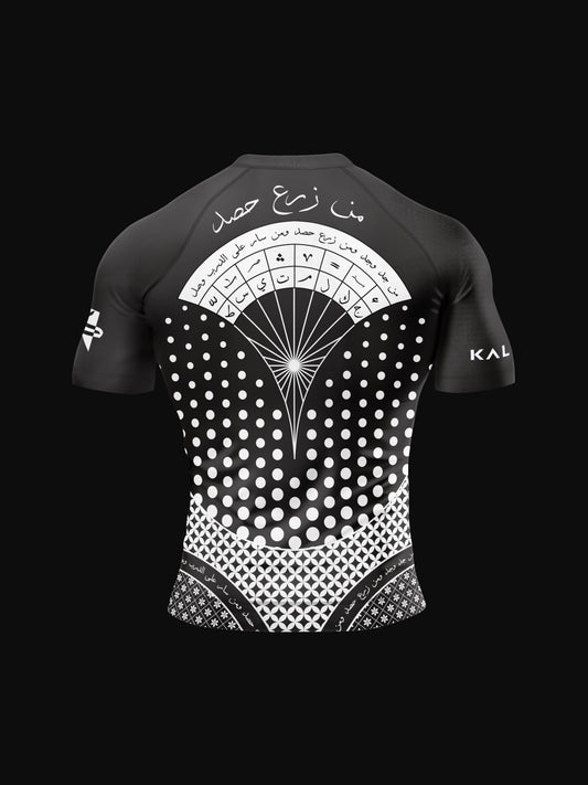 Black rashguard with arabic design, used for jiu-jitsu and other martial arts (e.g. MMA). This product features an exclusive print about a popular, common arabic expression regarding work, perseverance and achievement. Using thuluth, a type of arabic calligraphy, it exhibits a beautiful, geometrical style, featuring arabic lettering and symbols. It also gives a sensation of interstellar and space travel. Back view, black and white print color.