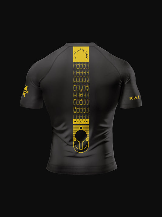 Black rashguard with arabic design, used for jiu-jitsu and other martial arts (e.g. MMA). This product features an exclusive print about a popular, common arabic expression regarding hope and optimism. Inspired by different types of arabic calligraphy, it exhibits a beautiful, geometrical style, featuring popular symbols such as the crescent, moon and stars. Backside view. Yellow and Green print color.