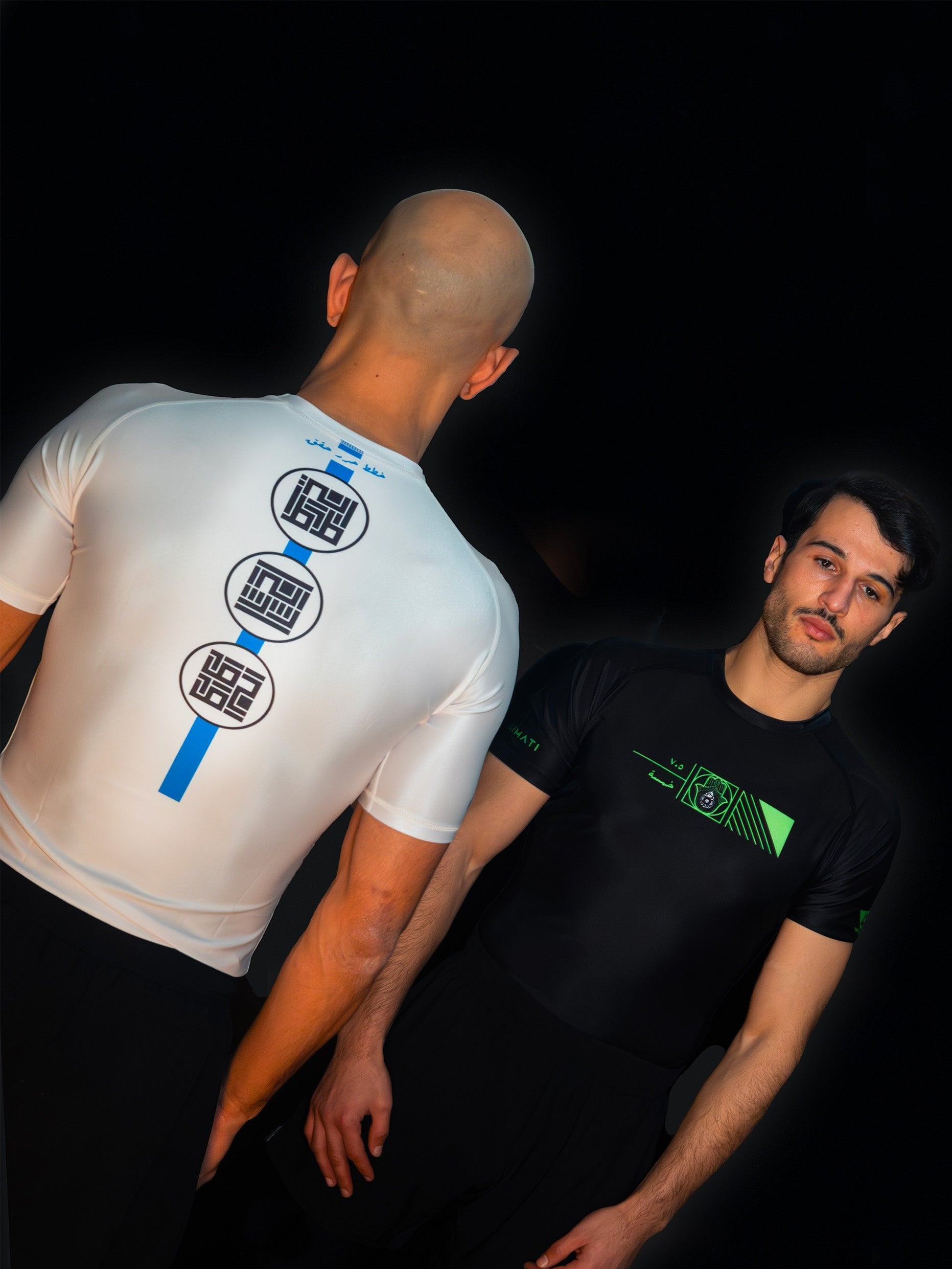 Two arabic fighters and martial artists facing each other. Each is wearing a cool, unique ashguard for jiujitsu and other combat sports. One is white and blue, the other is black and yellow.